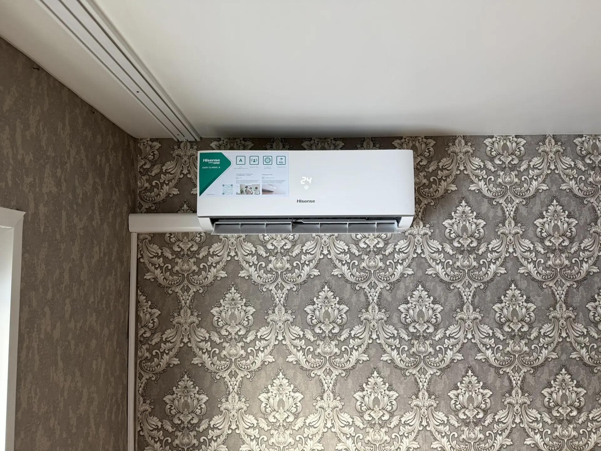 Кондиционер Hisense на стене с обоями, трасса в коробе вдоль угла